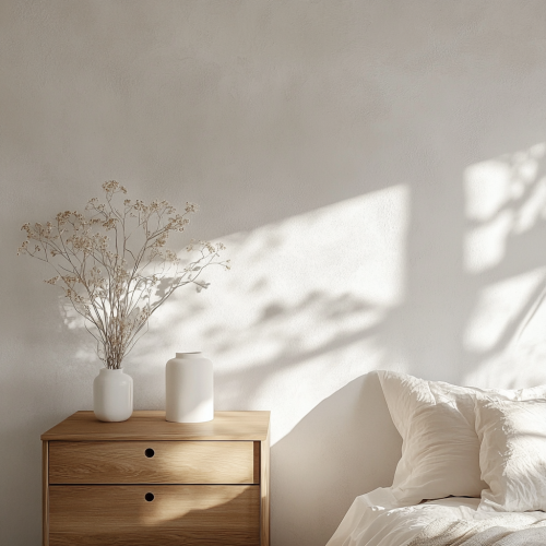 Zen bedroom with smooth white wall and minimalist dresser.