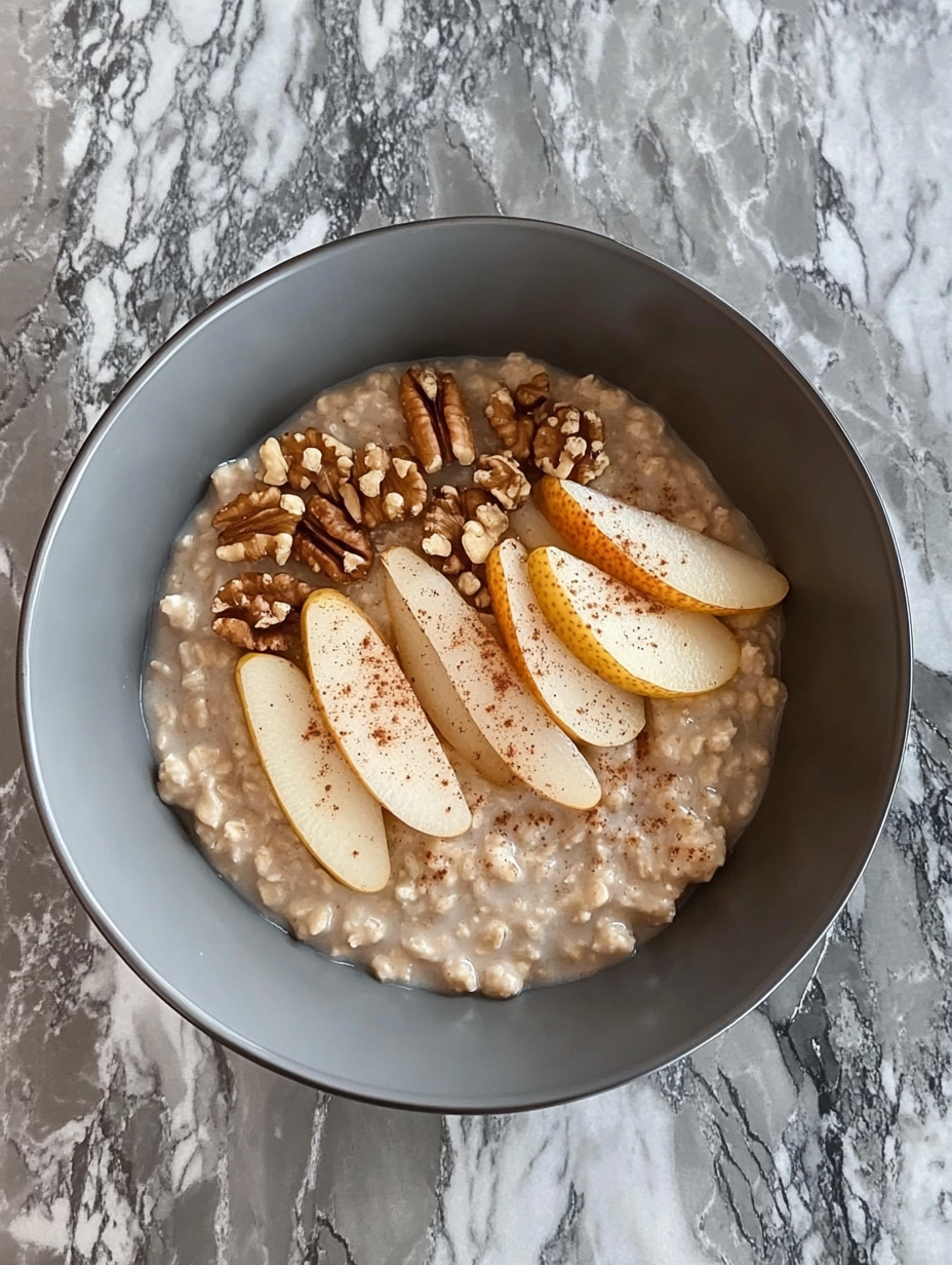 A cozy breakfast bowl with oatmeal, pear, and walnuts