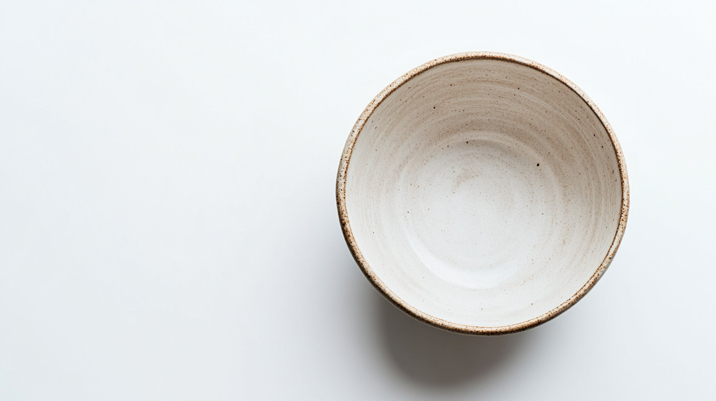 Empty deep bowl with earthy tones against white background.