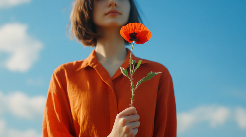 A Fashionable Woman Holding Poppy Flower Under Sky