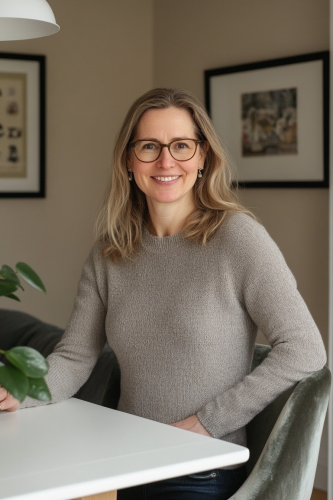 A woman in her mid-20s smiles in kitchen.