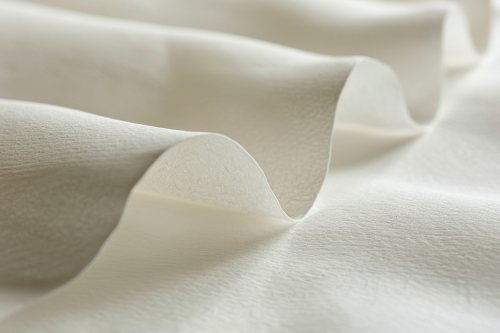 Close-up photograph of shiny white paper with textures