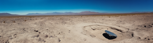 Crashed satellite in desert hole under sunny sky.