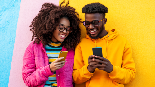 Happy young Afro-African men and women looking at phone.