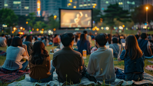Korean people watching movie outdoors in city park. Korean people watching movie outdoors in city park.