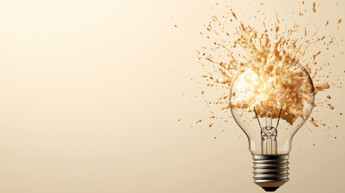 Lightbulb bursting with light, representing creativity, neutral background.