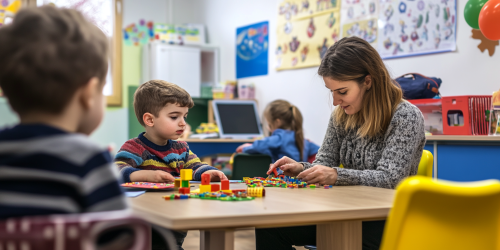 Patient teacher helps child with educational materials in classroom.