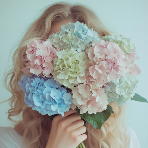 Woman holds colorful flowers in front of face