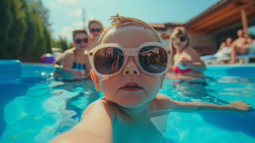Baby with sunglasses taking pool selfie