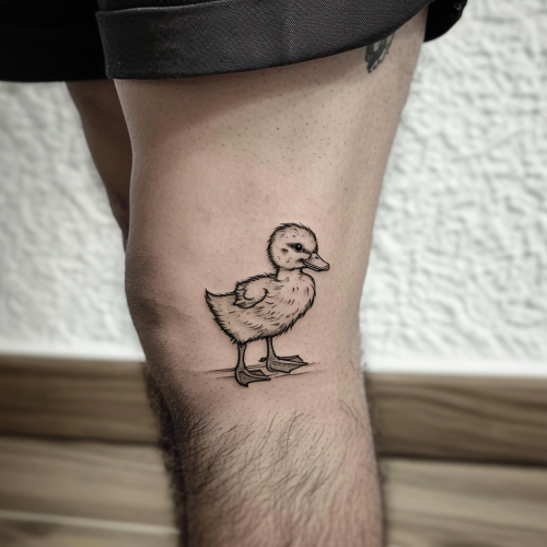 Baby duckling tattoo on man's leg
