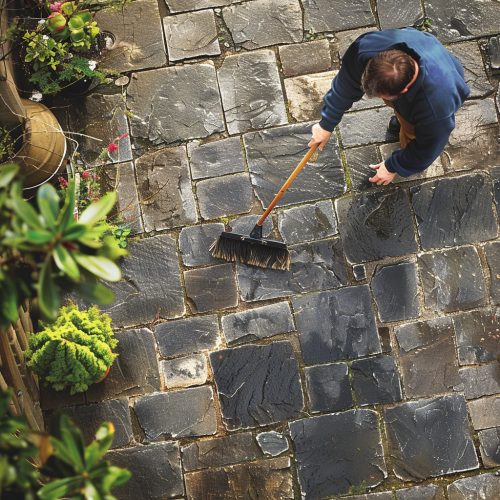 Man sweeping patio stones outdoors