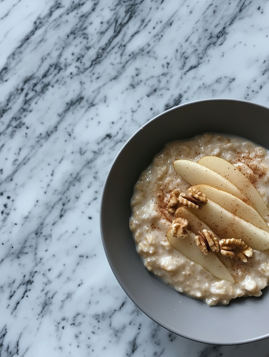 A cozy breakfast bowl with oatmeal, pear, and walnuts