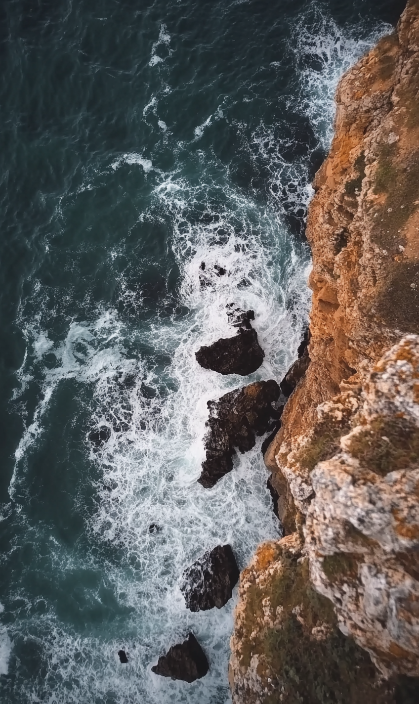 A person's POV looking down a stormy cliff