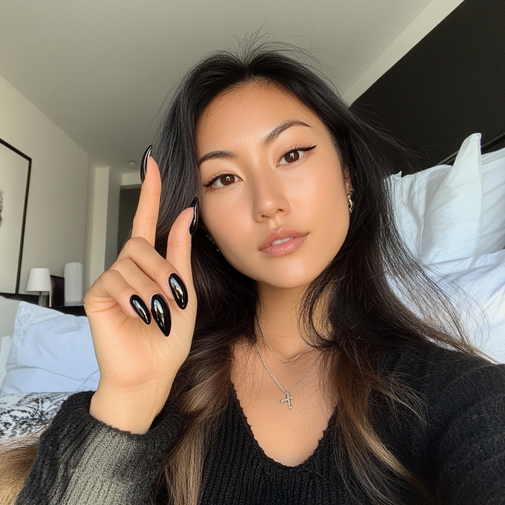 Asian woman showing nails painted black with chrome.