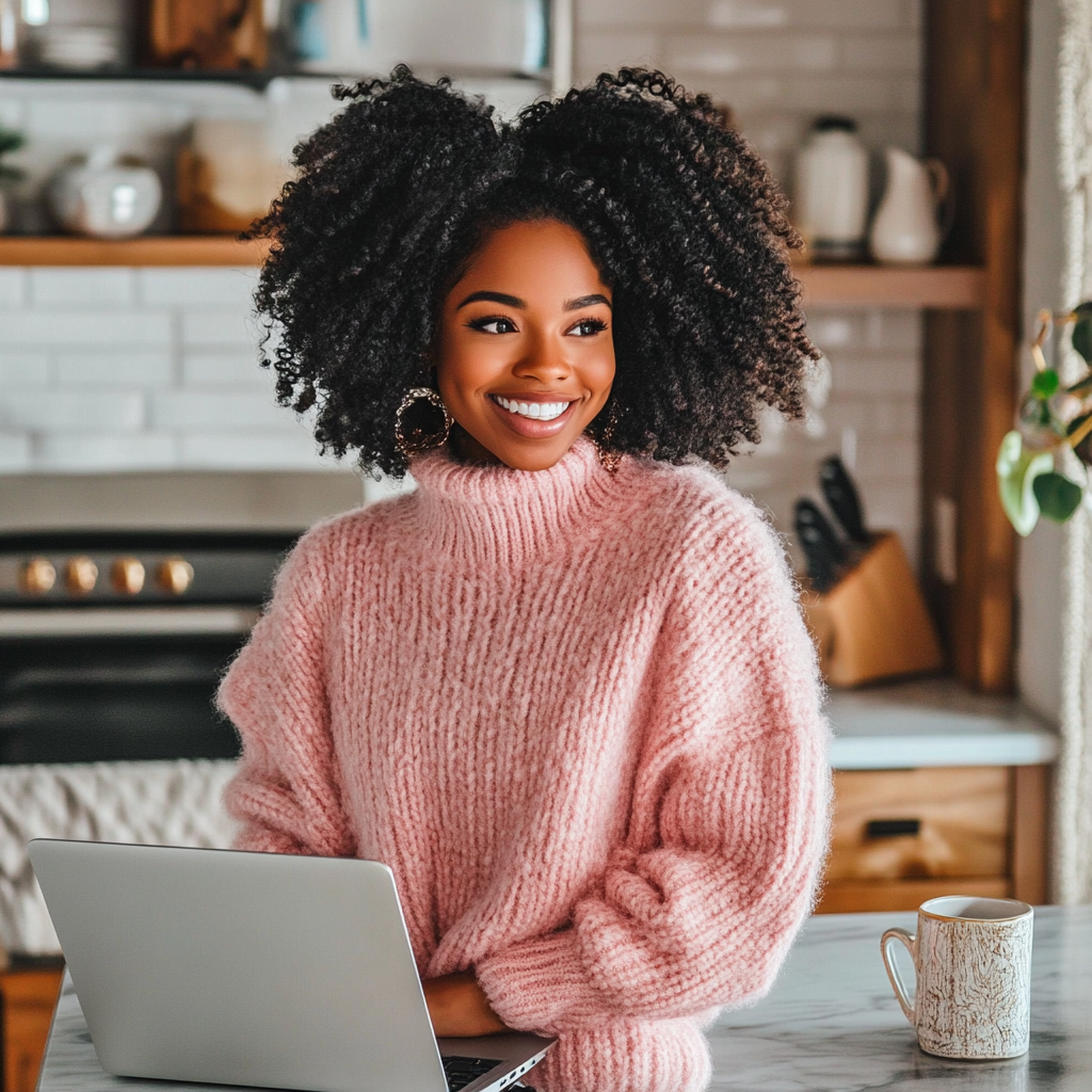 Beautiful black woman in pink sweater with computer.