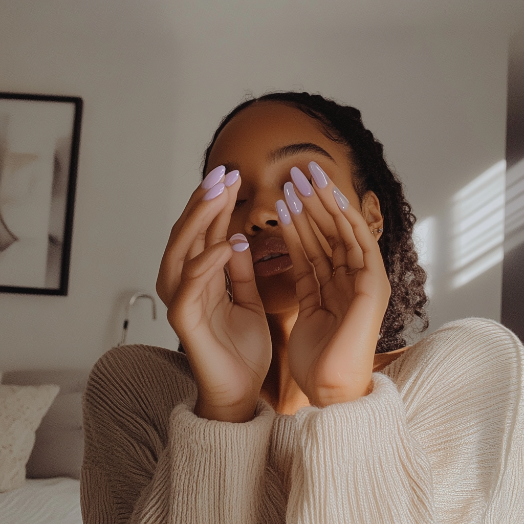 Candid photo of woman showing new lavender nails.