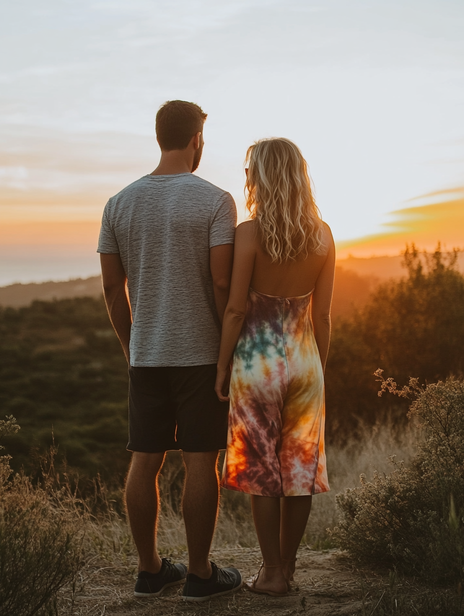 Couple in casual attire, looking at sunset view.