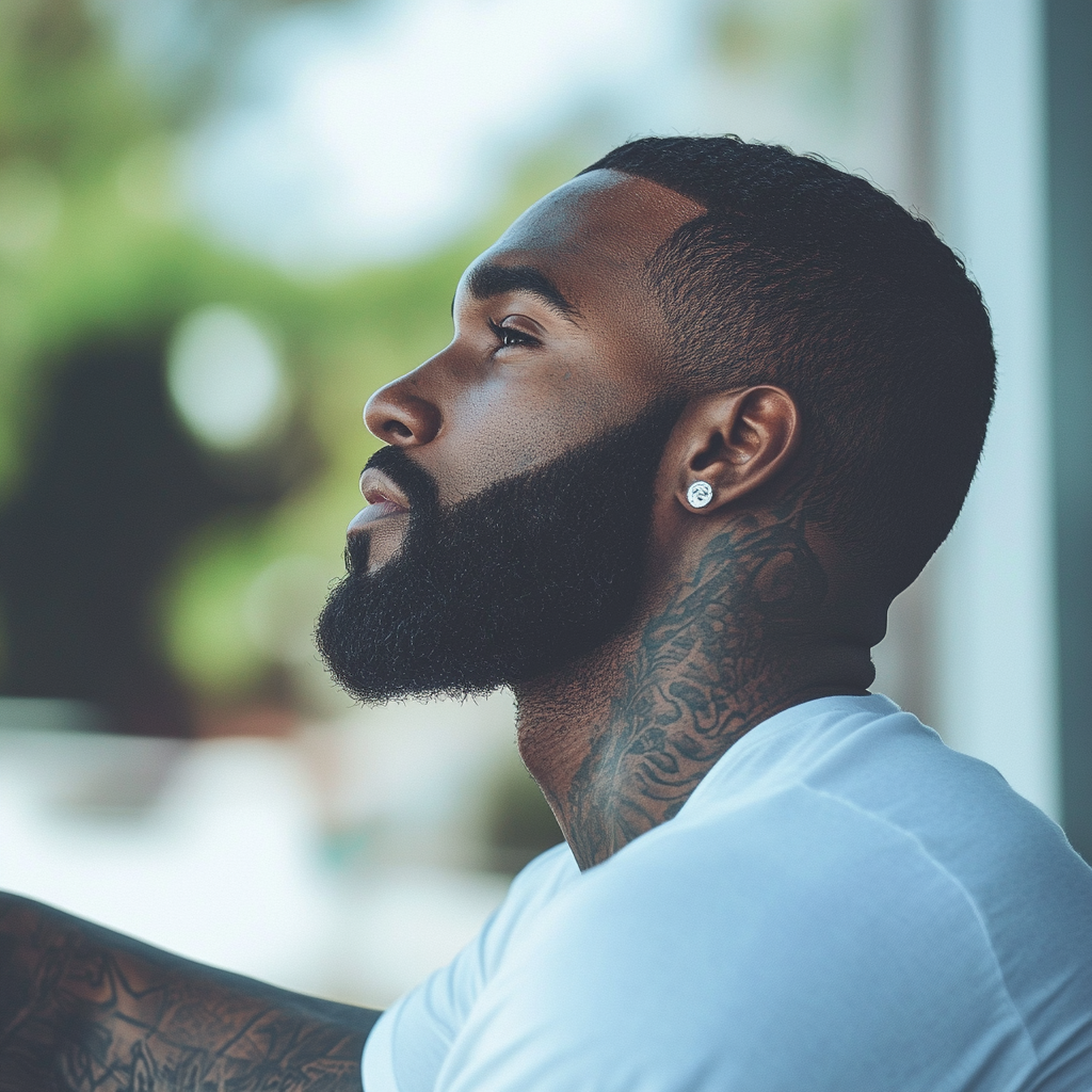 Dark-skinned man with close-cut, silky hair and sharp beard.