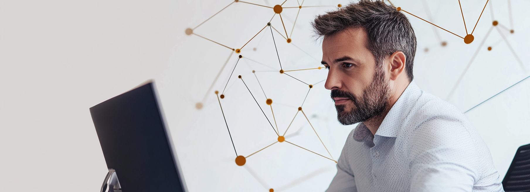 Man trades on computer with navy geometric shapes background.