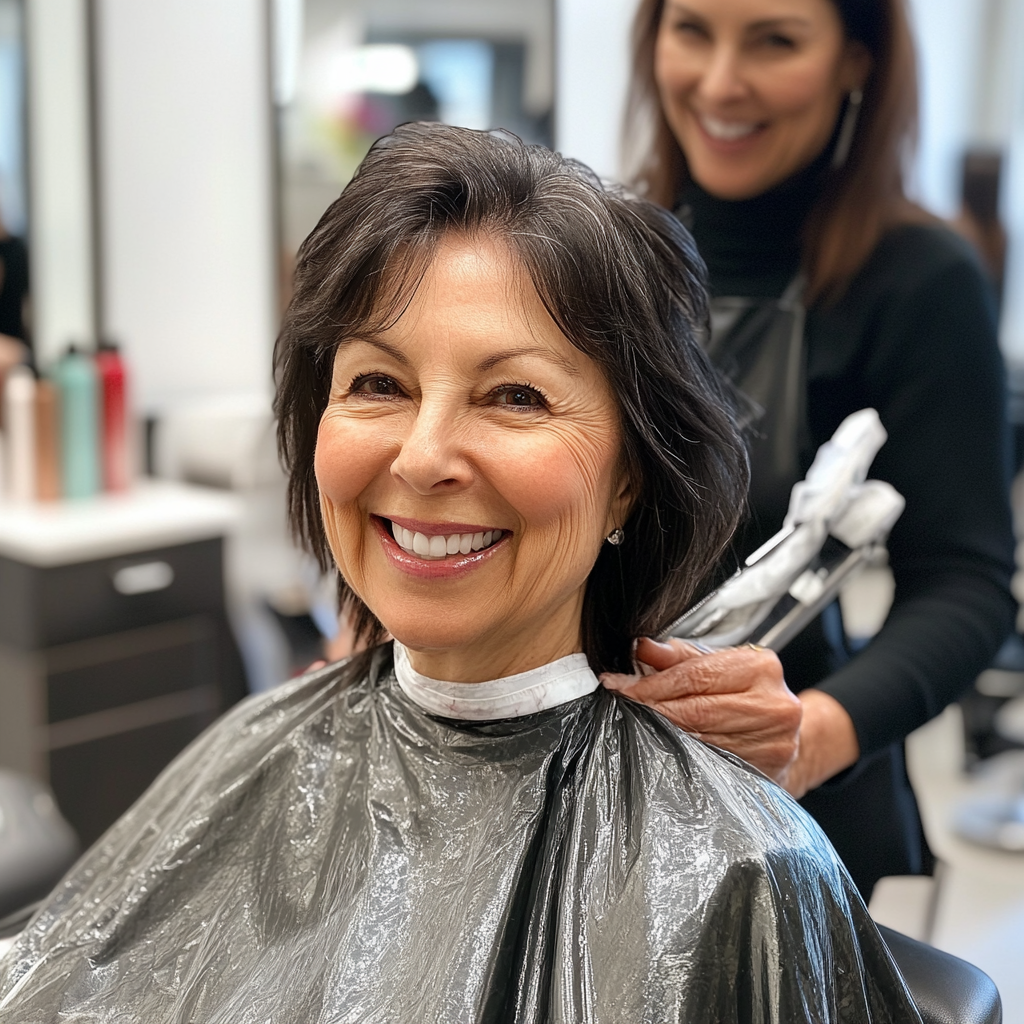 Smiling hair dresser cuts customer's hair