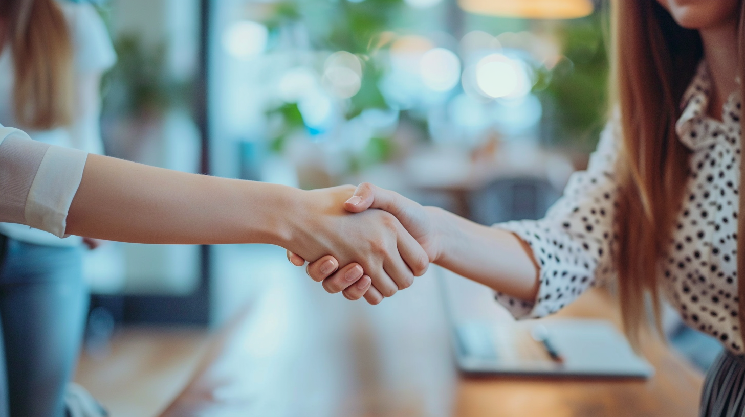 Business women shaking hands at table