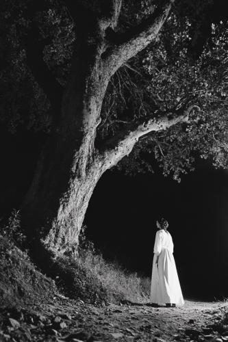 A Woman in White Witch with Flashlight at Night