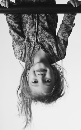 A happy girl on monkey bar, upside down