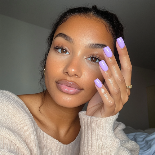 Candid photo of woman showing new lavender nails.