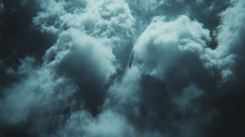 Dark US Fighter Jet Wing in Clouds