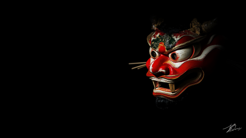 Japanese Hannya mask in center on black background