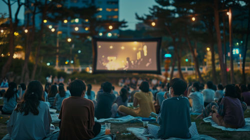 Korean people watching movie outdoors in city park. Korean people watching movie outdoors in city park.