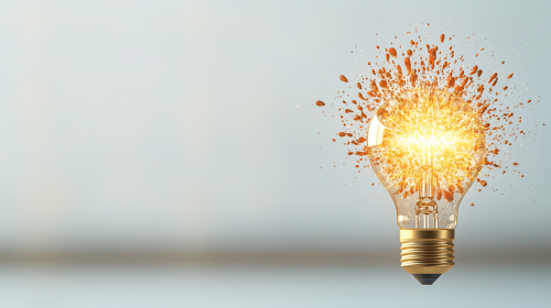 Lightbulb bursting with light, representing creativity, neutral background.
