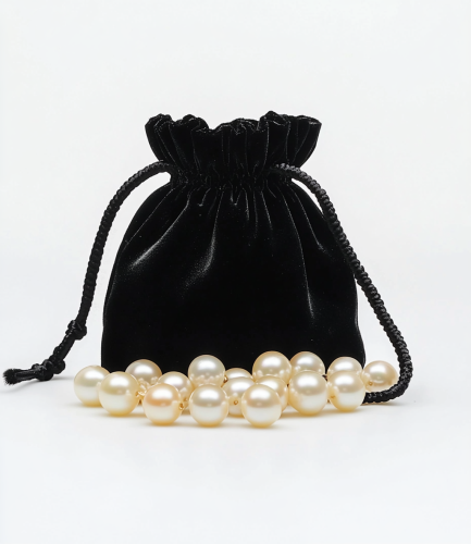 Pearls in a Black Velvet Bag on White Background