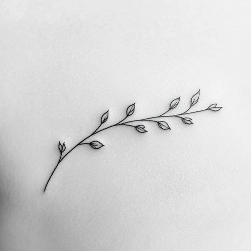 Simple black tattoo of delicate branch with buds
