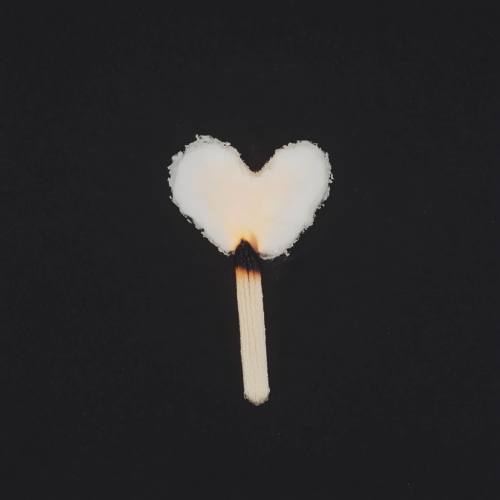 Two matchsticks in heart shape, flash photography, film.