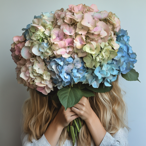 Woman holds colorful flowers in front of face