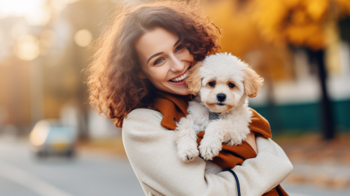 Happy woman with cute poodle puppy outside