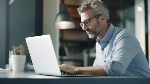Man typing on laptop in small office