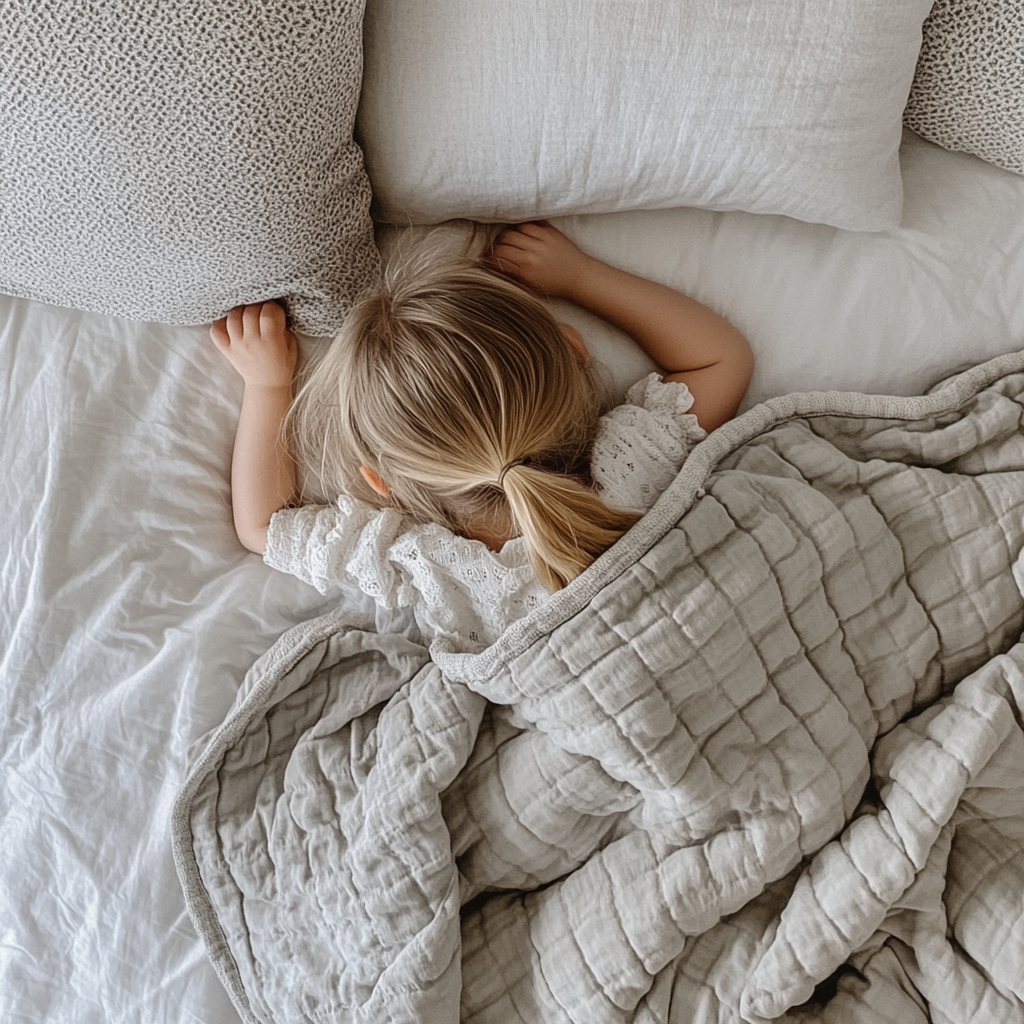 A Little Girl Napping Under Grey Duvet.