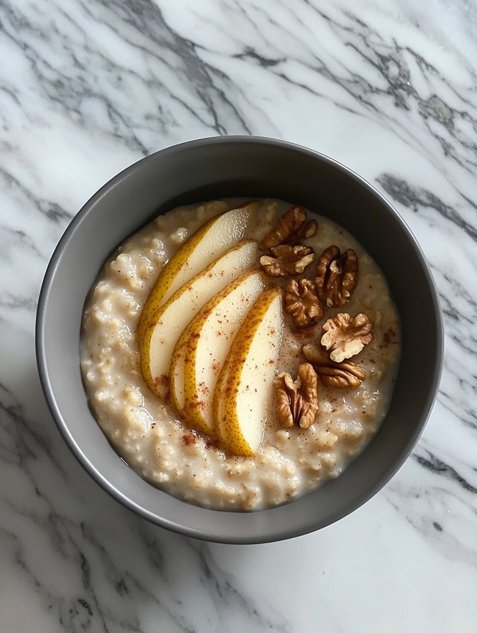 A cozy breakfast bowl with oatmeal, pear, and walnuts