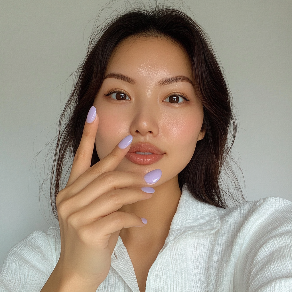 Candid Asian woman showing off new lavender nails.