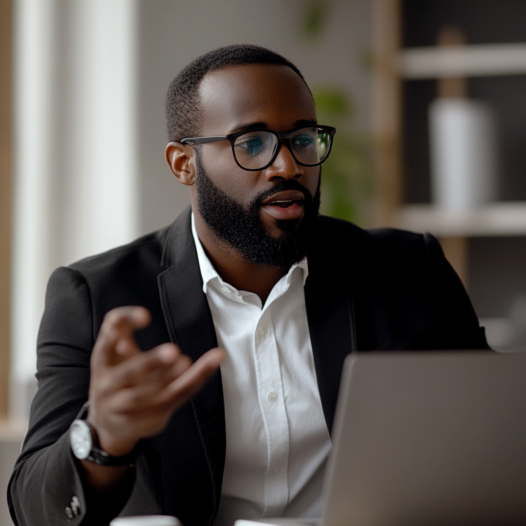 Confident salesman in suit presenting product in bright office.