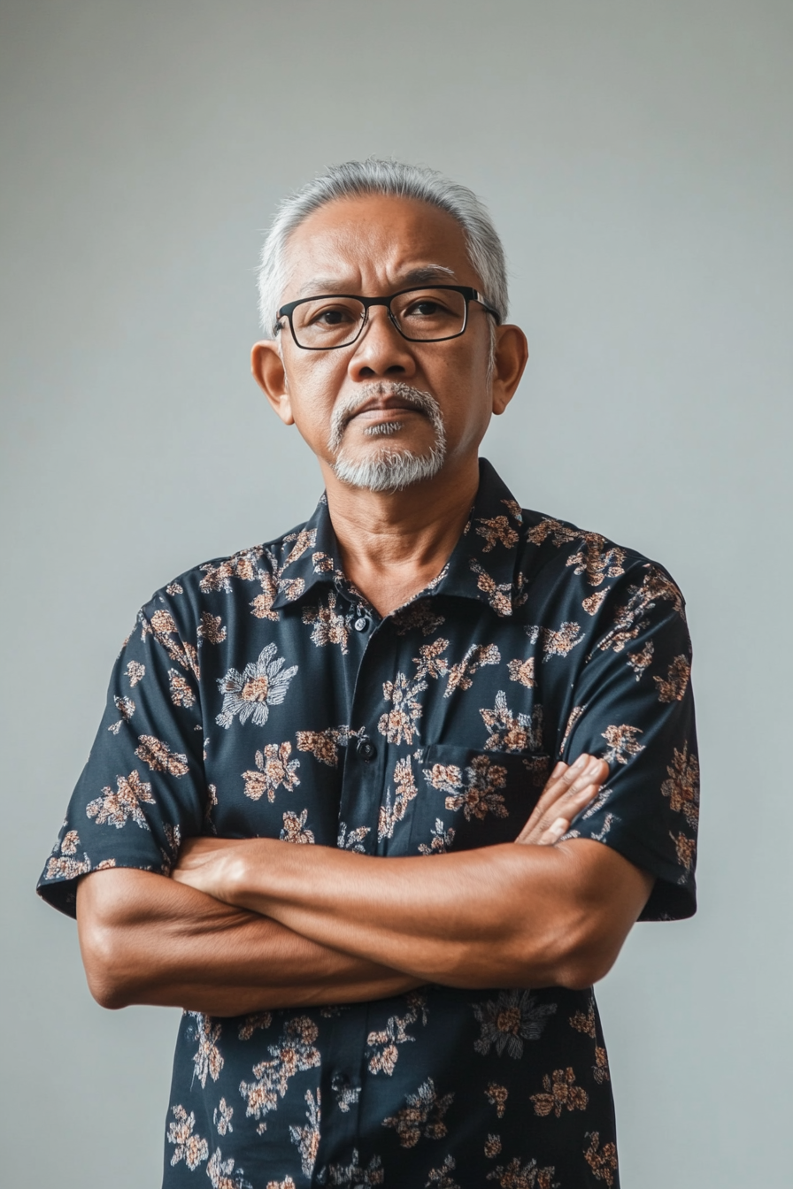 Focused Malay man in running shirt stands aggressively.