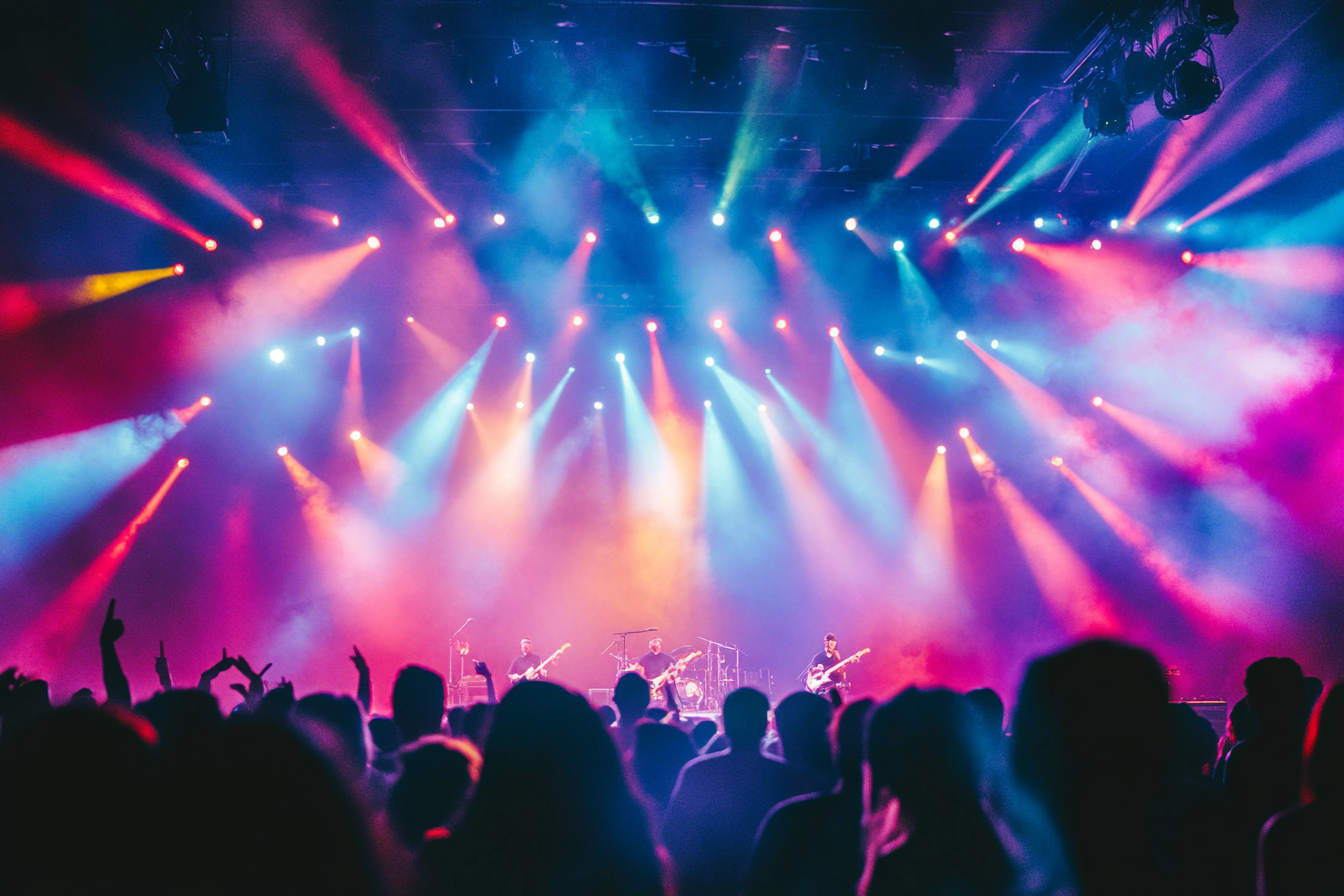 People enjoying music with colorful lights and tables