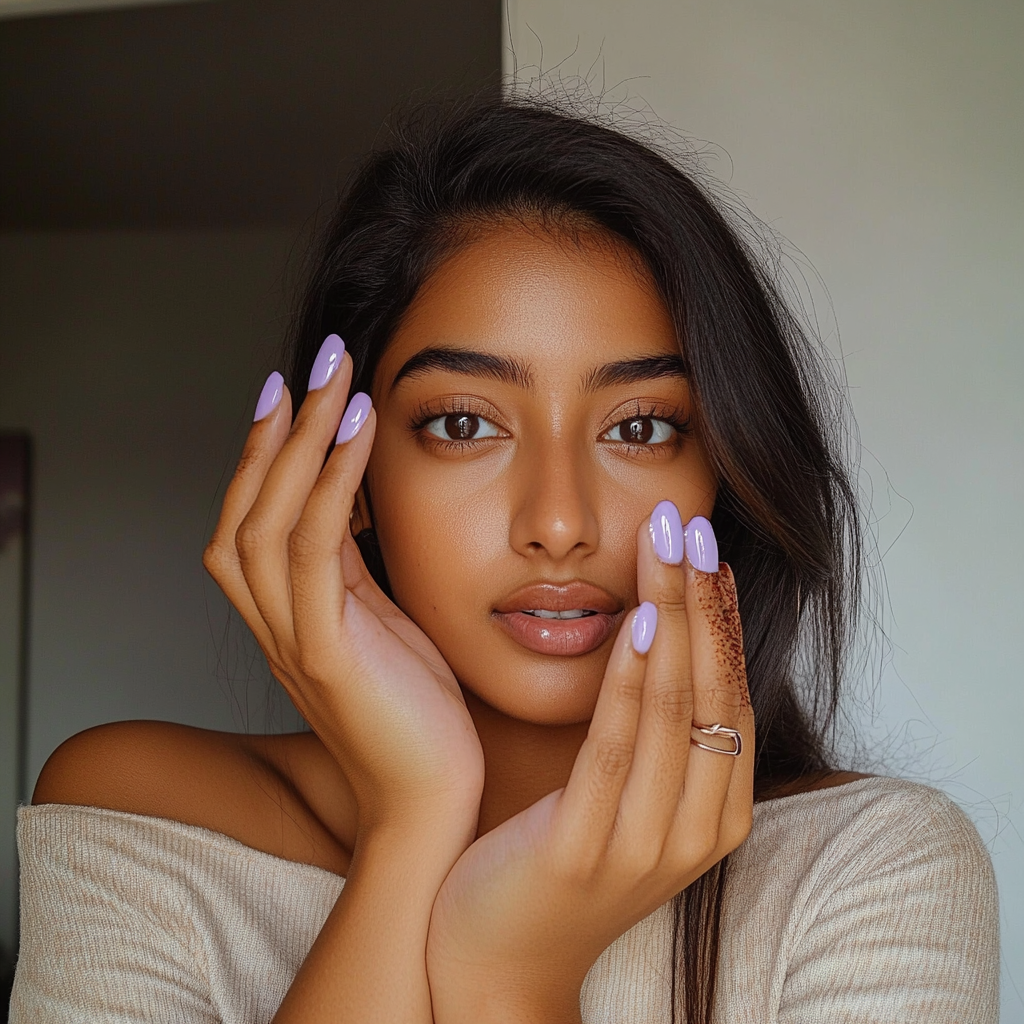 Photo of Indian woman showing glossy lavender nails.