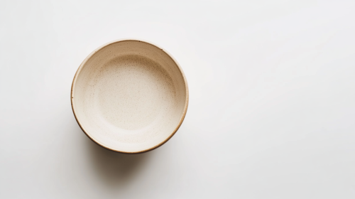 Empty deep bowl with earthy tones against white background.
