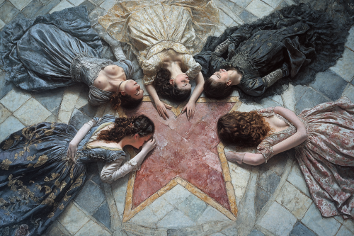 Five women in old-fashioned dresses on heart-printed floor