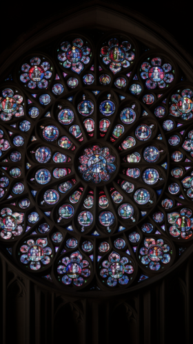 Intricate gothic stained glass rose window in dark pastels. Intricate gothic stained glass rose window in dark pastels.