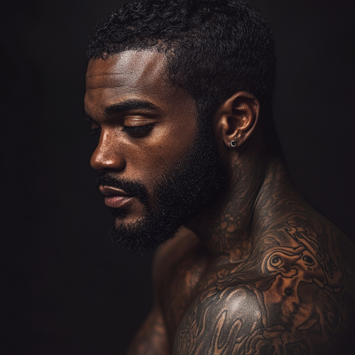 Man with tattoos, deep in thought, head turned left.