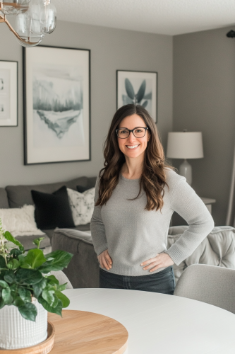 Smiling woman in grey room with plants and art.